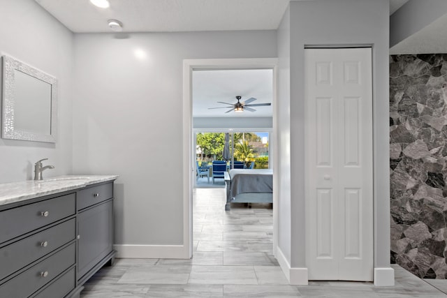 9029 SE Breeze Way, Hobe Sound, FL 33455 - ensuite bathroom with ensuite bath, baseboards, vanity, and ceiling fan