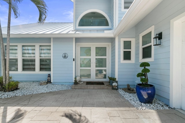 9029 SE Breeze Way, Hobe Sound, FL 33455 - entrance to property featuring french doors, metal roof, and a standing seam roof