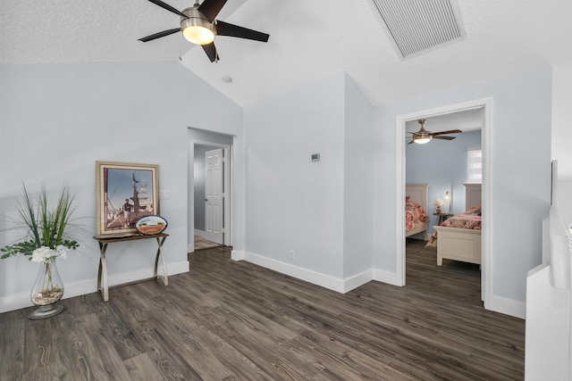 spare room featuring ceiling fan, a textured ceiling, vaulted ceiling, and dark hardwood / wood-style floors