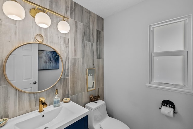 bathroom featuring tile walls, vanity, toilet, and walk in shower