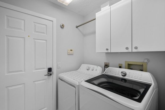 9029 SE Breeze Way, Hobe Sound, FL 33455 - laundry area featuring a textured ceiling, independent washer and dryer, and cabinet space
