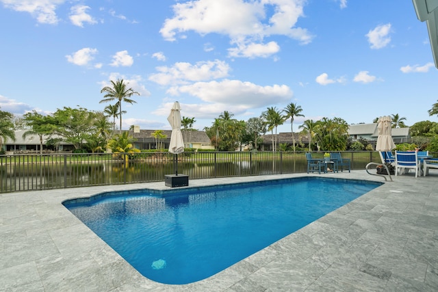 view of pool with a patio area and a water view