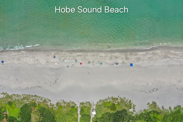 drone / aerial view with a water view and a beach view