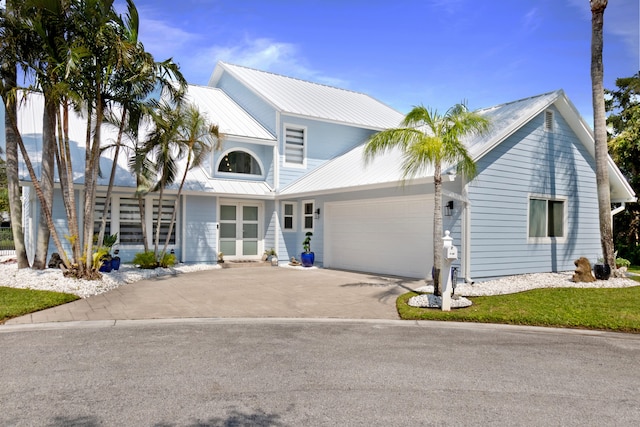9029 SE Breeze Way, Hobe Sound, FL 33455 - traditional-style house featuring concrete driveway, metal roof, and a garage