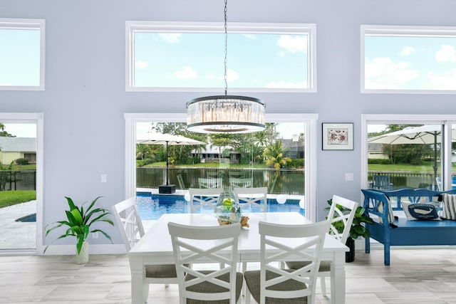 dining area with an inviting chandelier, a high ceiling, and a water view