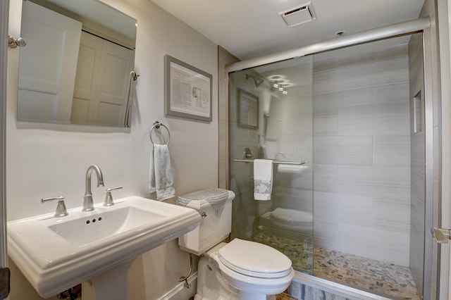 bathroom featuring walk in shower, sink, and toilet