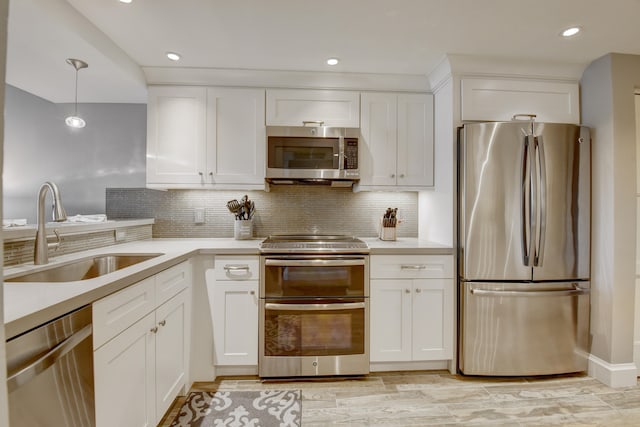 kitchen with sink, appliances with stainless steel finishes, tasteful backsplash, and white cabinetry