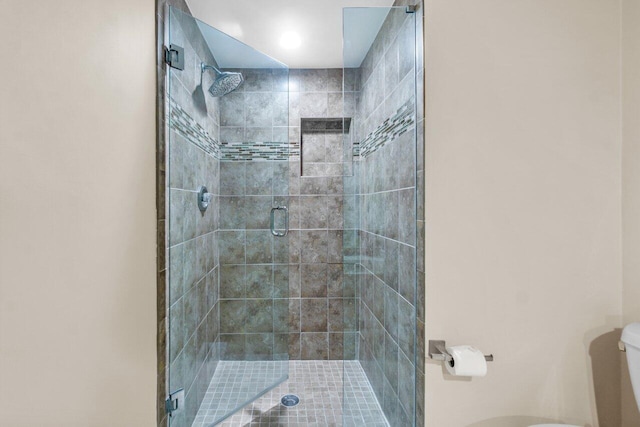 bathroom with a shower with door and toilet