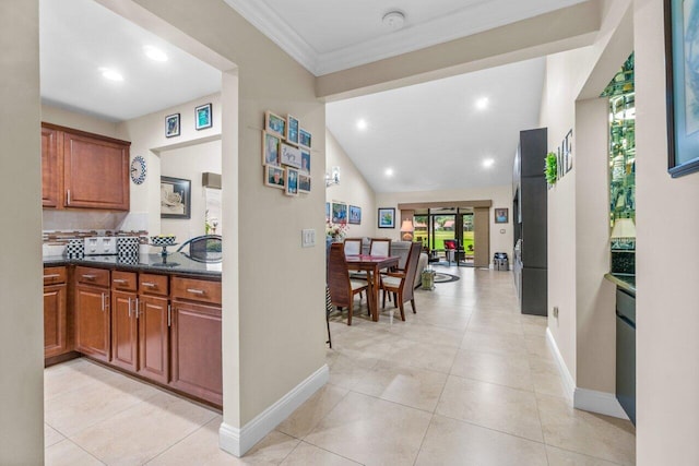 kitchen featuring vaulted ceiling, backsplash, and light tile flooring