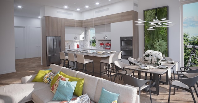 kitchen with a healthy amount of sunlight, stainless steel refrigerator, double oven, white cabinetry, and a high ceiling