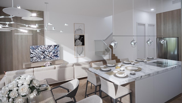 kitchen featuring light stone counters, stainless steel fridge, and black electric cooktop