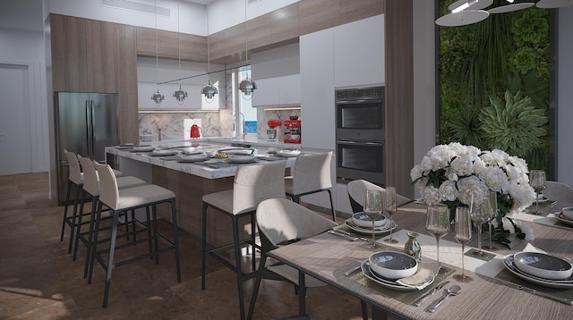 kitchen featuring a towering ceiling, tasteful backsplash, white cabinets, tile floors, and black double oven