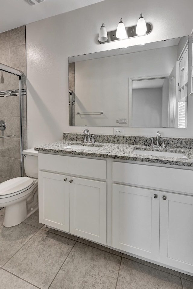 bathroom with tile floors, dual vanity, toilet, and walk in shower