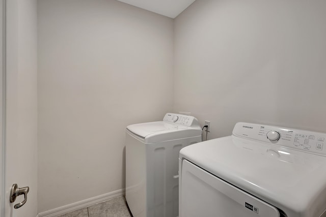 laundry room featuring light tile floors and washing machine and dryer