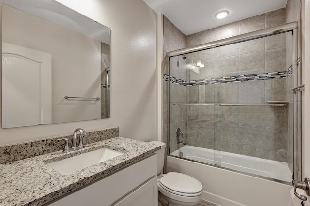 full bathroom featuring toilet, bath / shower combo with glass door, and large vanity