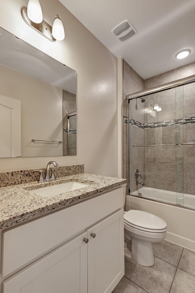 full bathroom featuring tile floors, combined bath / shower with glass door, toilet, and large vanity