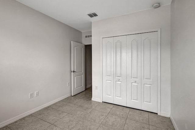 unfurnished bedroom with a closet and light tile flooring