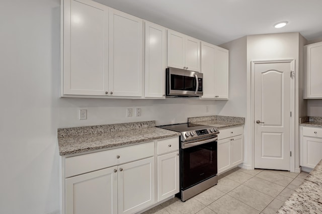 kitchen featuring stainless steel appliances, white cabinets, and light tile floors