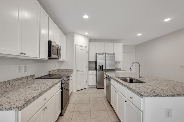 kitchen with stainless steel appliances, sink, light tile floors, and a kitchen island with sink