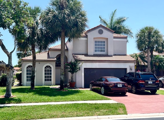 mediterranean / spanish-style house with a garage and a front yard