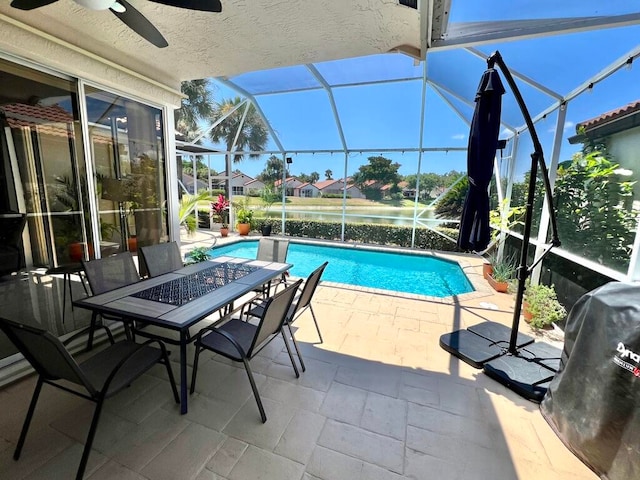 view of swimming pool with ceiling fan, a patio, and a lanai