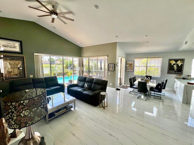 living room featuring a healthy amount of sunlight, ceiling fan, and vaulted ceiling