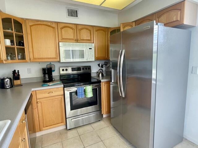 kitchen featuring stainless steel appliances and light tile floors