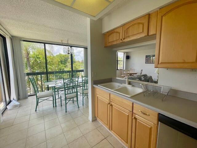 kitchen featuring dishwasher, sink, plenty of natural light, and a textured ceiling