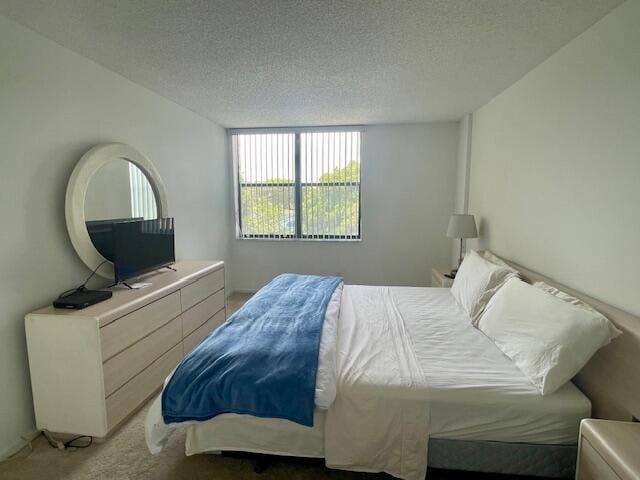 carpeted bedroom featuring a textured ceiling