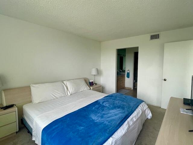 bedroom featuring a textured ceiling and carpet floors