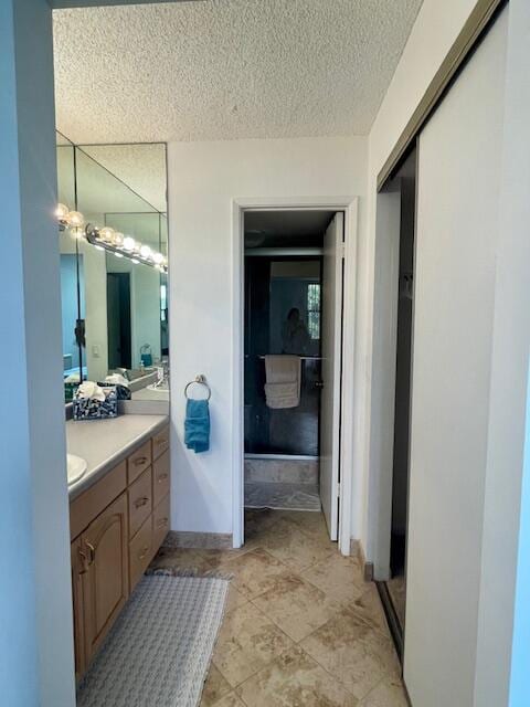 bathroom featuring tile flooring, vanity, and a textured ceiling