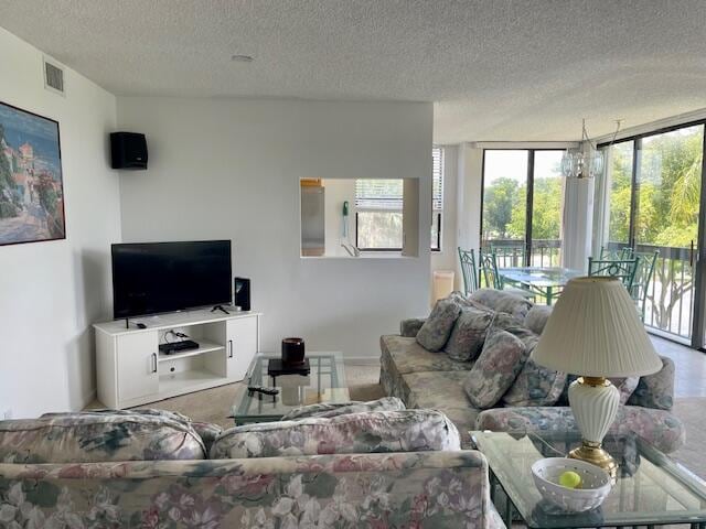 living room with carpet flooring, a chandelier, and a textured ceiling