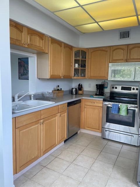 kitchen with sink, light tile floors, and stainless steel appliances