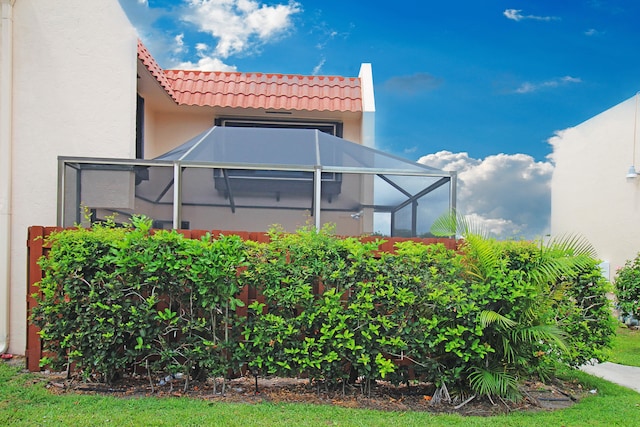 view of side of home with glass enclosure