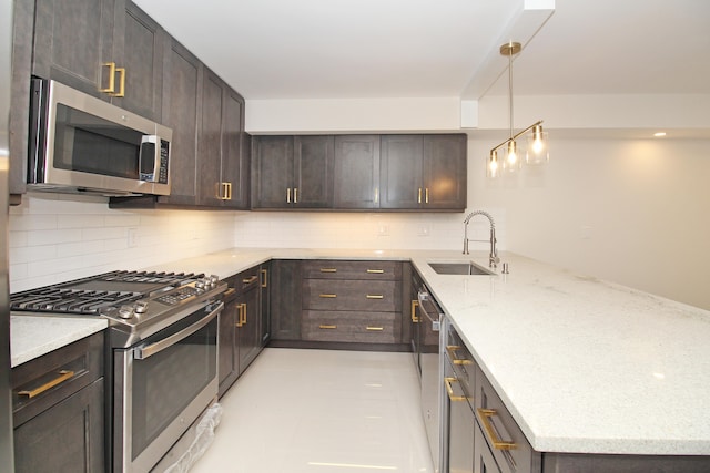 kitchen featuring light stone countertops, stainless steel appliances, backsplash, sink, and light tile floors