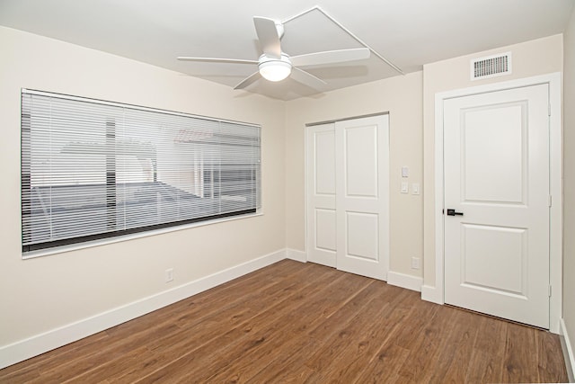 unfurnished bedroom with dark hardwood / wood-style flooring, a closet, and ceiling fan