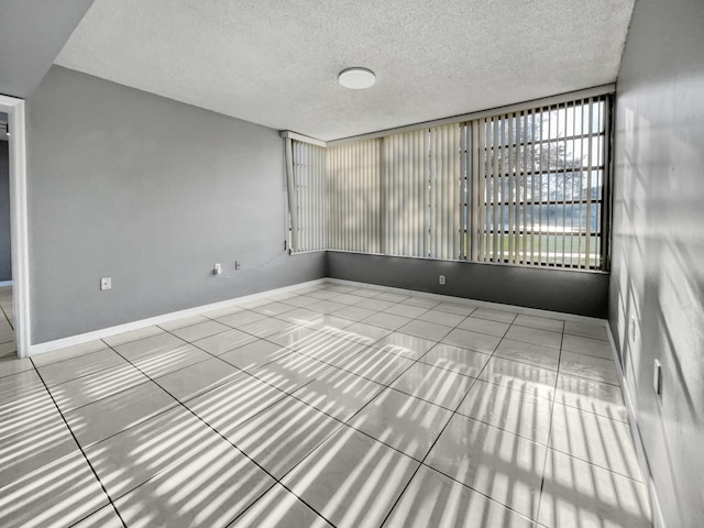 empty room with tile flooring and a textured ceiling