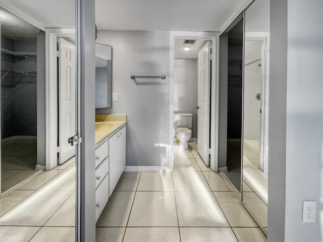 bathroom with vanity, tile floors, and toilet