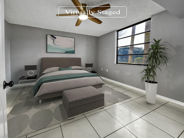 bedroom with ceiling fan, tile floors, and a textured ceiling