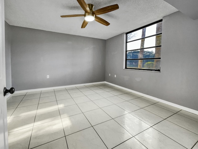 tiled spare room with ceiling fan and a textured ceiling