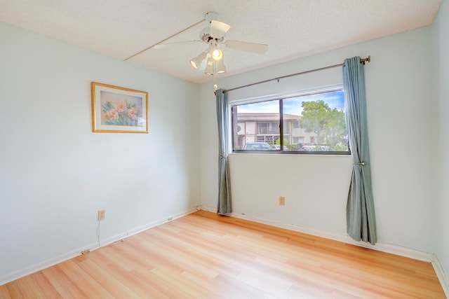 empty room featuring light hardwood / wood-style flooring, a textured ceiling, and ceiling fan