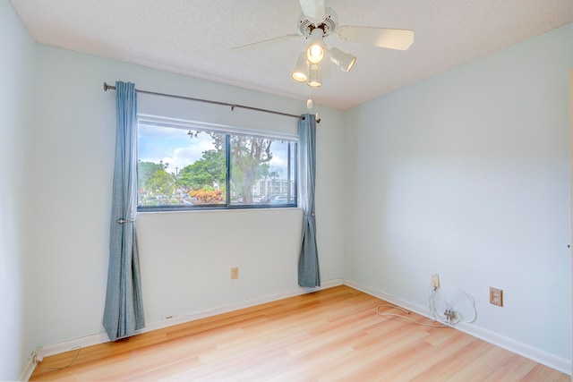 unfurnished room featuring ceiling fan, wood-type flooring, and a textured ceiling