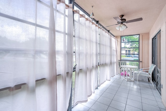 unfurnished sunroom featuring ceiling fan