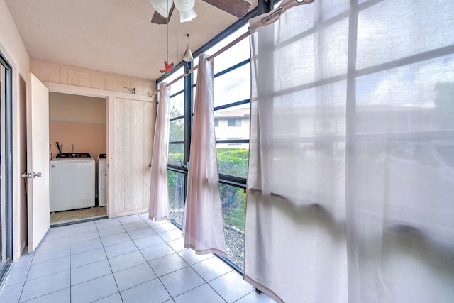 unfurnished sunroom featuring independent washer and dryer and ceiling fan