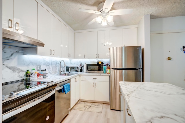 kitchen featuring sink, appliances with stainless steel finishes, white cabinetry, and light hardwood / wood-style floors