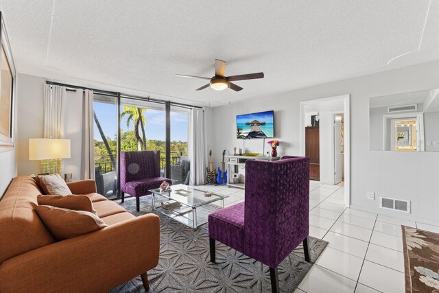 tiled living room featuring ceiling fan and a textured ceiling