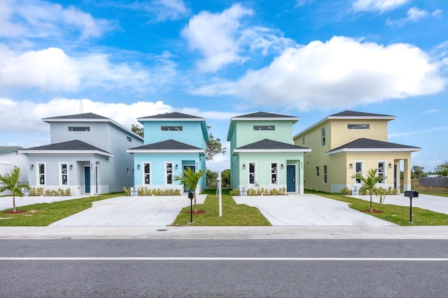 view of front of property featuring concrete driveway and a front yard