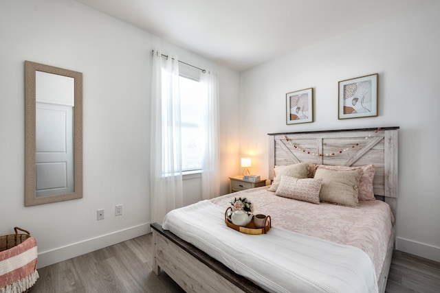 bedroom with wood finished floors and baseboards