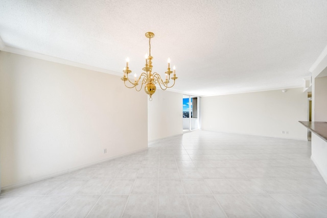 spare room featuring ornamental molding, a textured ceiling, and a chandelier