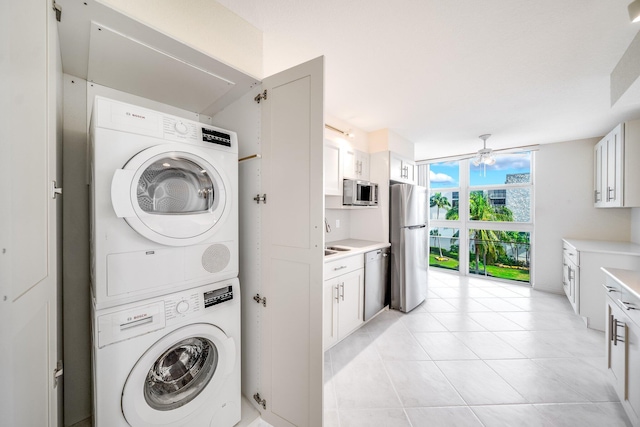 clothes washing area with stacked washer and dryer and ceiling fan